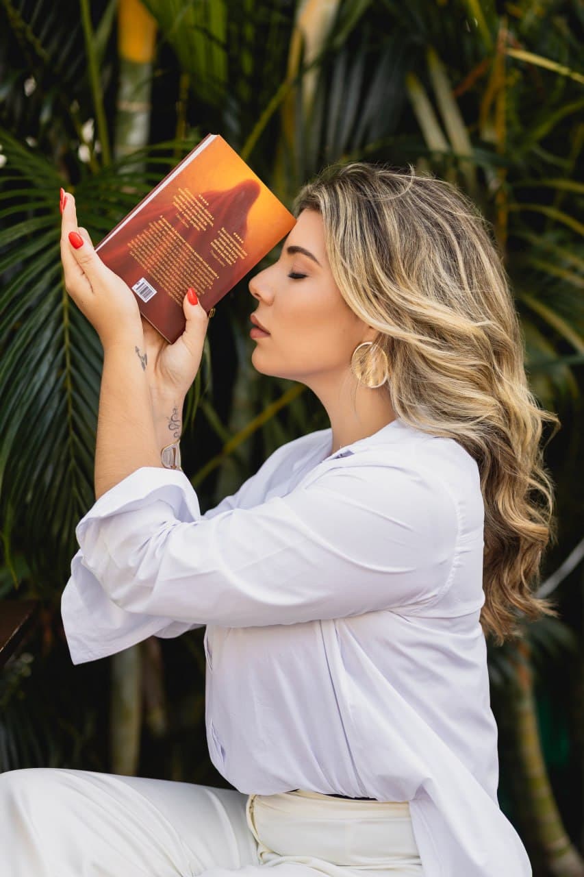 Bia Munareto com o livro junto ao rosto